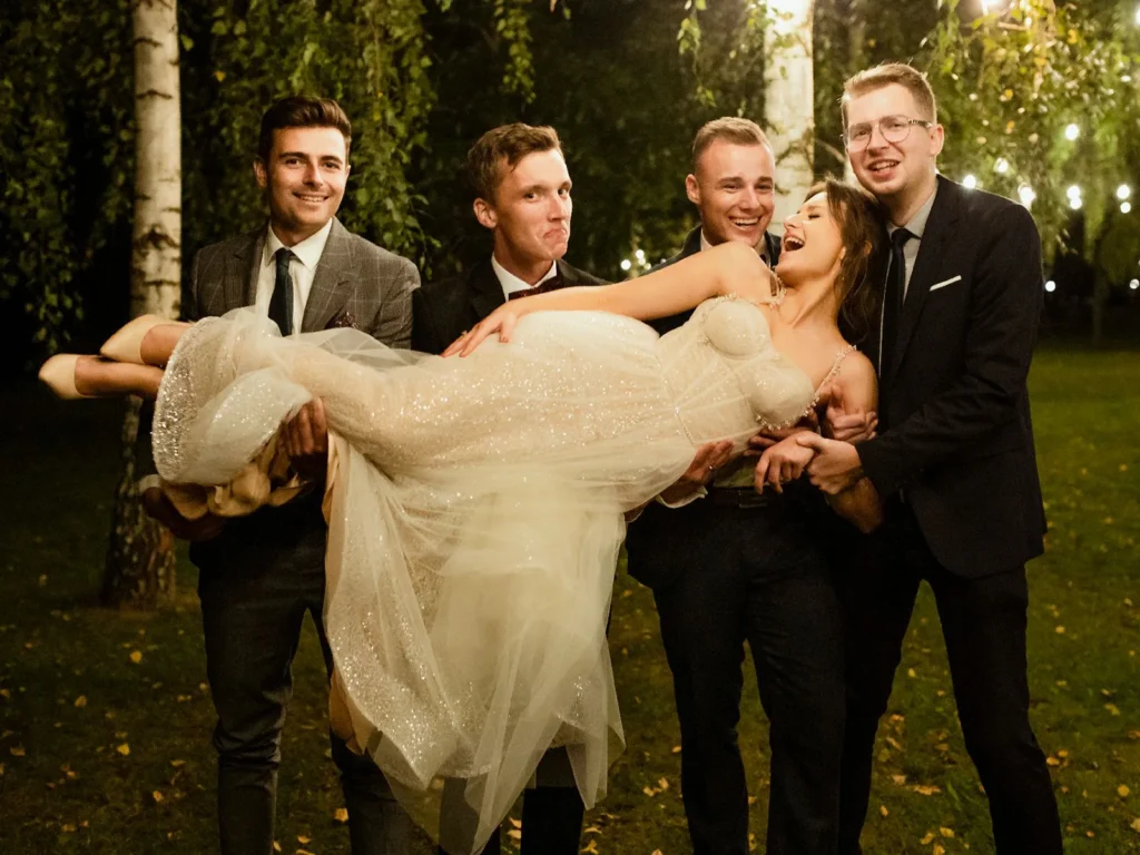 Brud bliver løftet af en gruppe venner i en sjov og livlig bryllupsscene, fotograferet af bryllupsfotograf på Sjælland nær København.