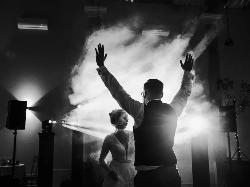 Brudepar danser i dramatisk lys og røg, fotograferet i sort-hvid af bryllupsfotograf på Sjælland nær København.