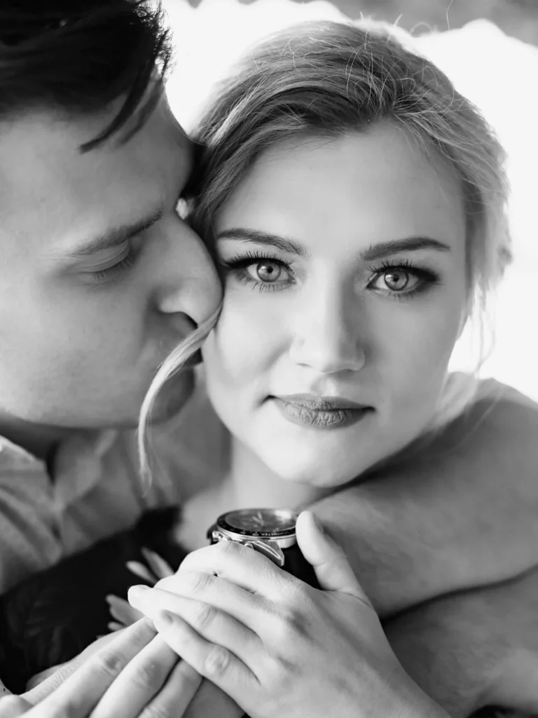 Intimt sort-hvidt portræt af et par, hvor manden kysser kvindens kind, fotograferet af bryllupsfotograf på Sjælland nær København.