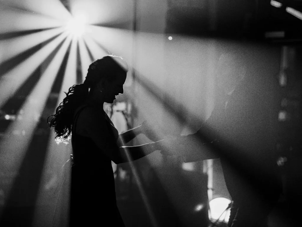 Silhuet af en kvinde og en mand, der danser under dramatisk belysning, fanget af en bryllupsfotograf i København.