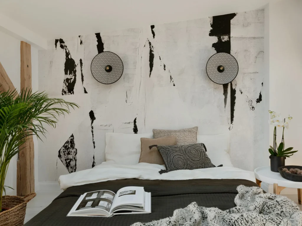 Moderne soveværelse med kunstnerisk vægdekoration og stilfulde detaljer.